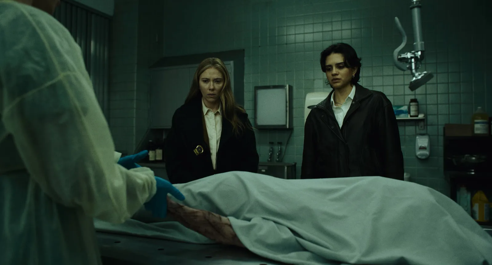 Julie Miller (Scarlett Johansson) et Gina (Sasha Calle) devant une table d’autopsie, dans The Exorcist: Martyrs